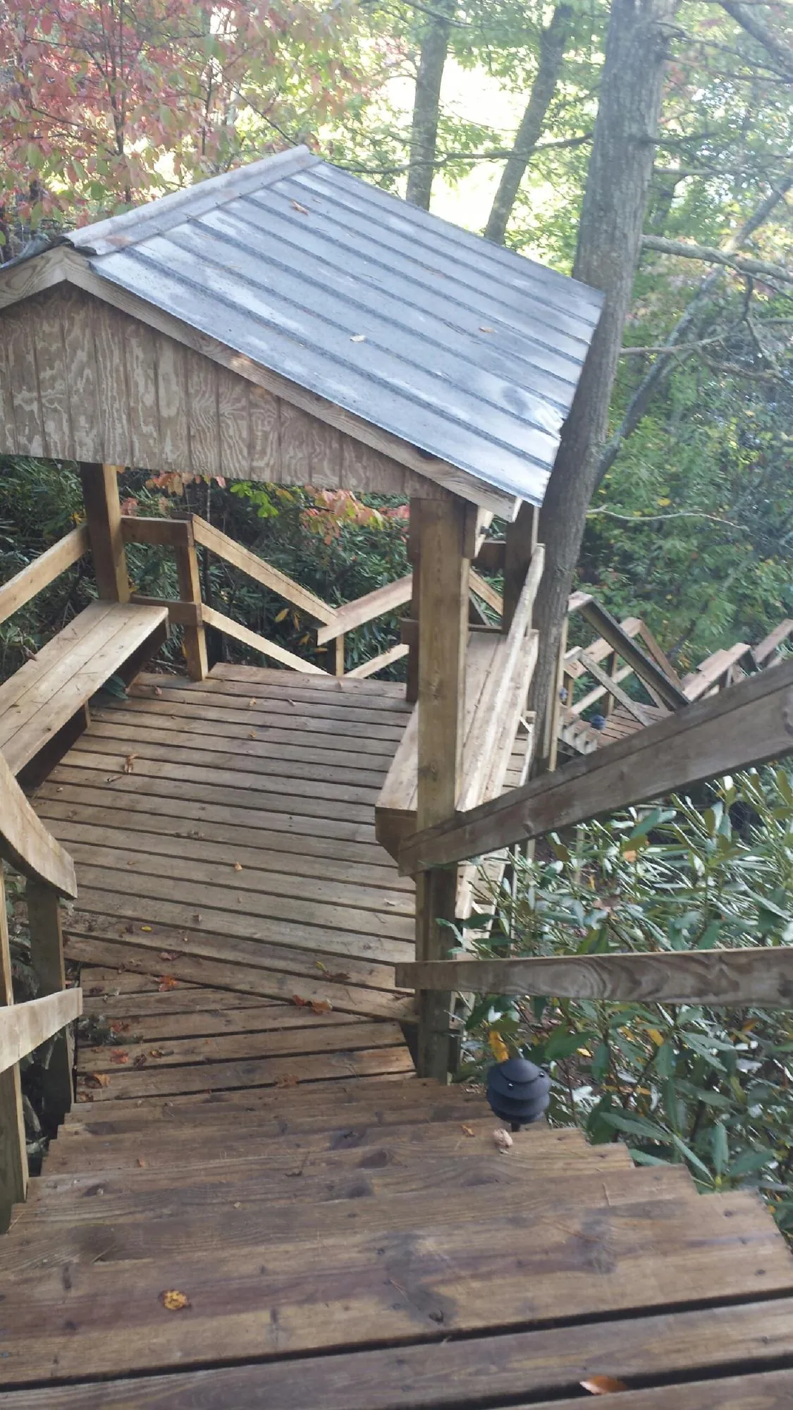Metal roofed shelter over wooden steps on a wooded walkway — Skylight Repair & Installation work by our crew in Atwater