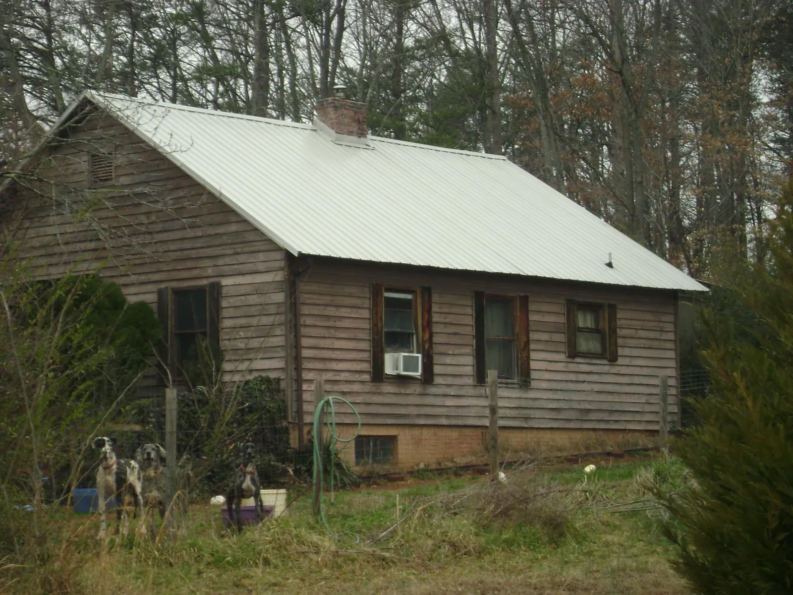 White metal roof on an old wood sided farmhouse, from a Metal Roof Installation job in Atwater